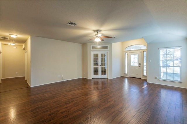 unfurnished living room with ceiling fan, french doors, and dark wood-type flooring