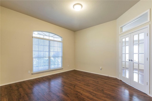 spare room with french doors and dark wood-type flooring