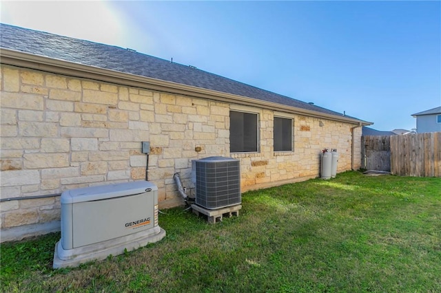 rear view of house with a lawn and central AC