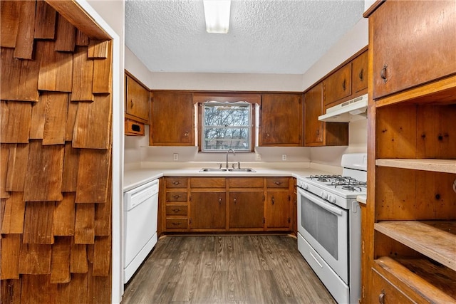 kitchen featuring white appliances, a textured ceiling, dark hardwood / wood-style floors, and sink