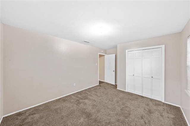 unfurnished bedroom featuring a closet and carpet flooring