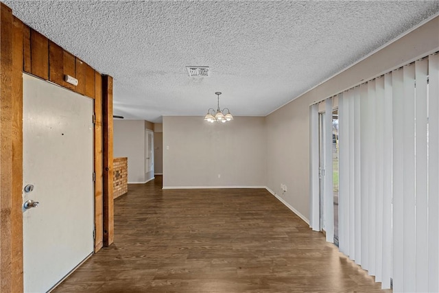 interior space featuring dark hardwood / wood-style flooring, an inviting chandelier, and a textured ceiling