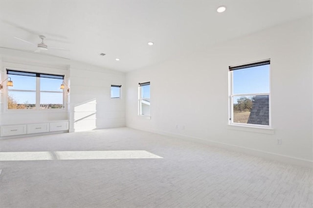 carpeted spare room with ceiling fan, a healthy amount of sunlight, and lofted ceiling