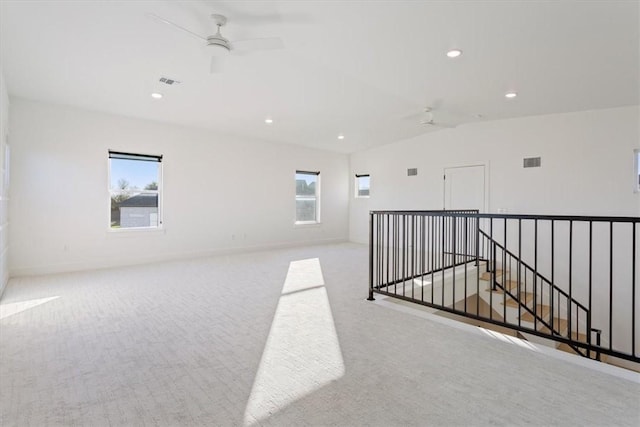 empty room featuring ceiling fan, light colored carpet, and lofted ceiling