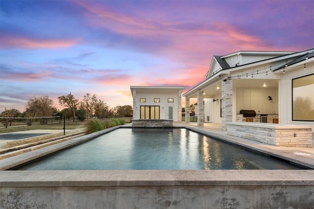 pool at dusk with an outbuilding