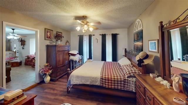 bedroom with ceiling fan, dark hardwood / wood-style flooring, and a textured ceiling