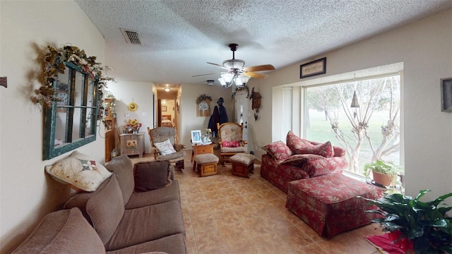 living room with ceiling fan, a healthy amount of sunlight, and a textured ceiling