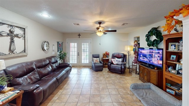 living room with ceiling fan, french doors, light tile patterned flooring, and a textured ceiling