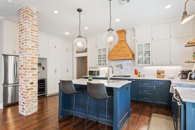 kitchen featuring white cabinets, blue cabinets, dark wood-type flooring, and stainless steel refrigerator