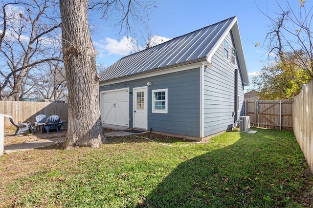 view of outdoor structure with central air condition unit, a yard, and a garage