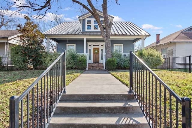 bungalow-style house with covered porch and a front lawn