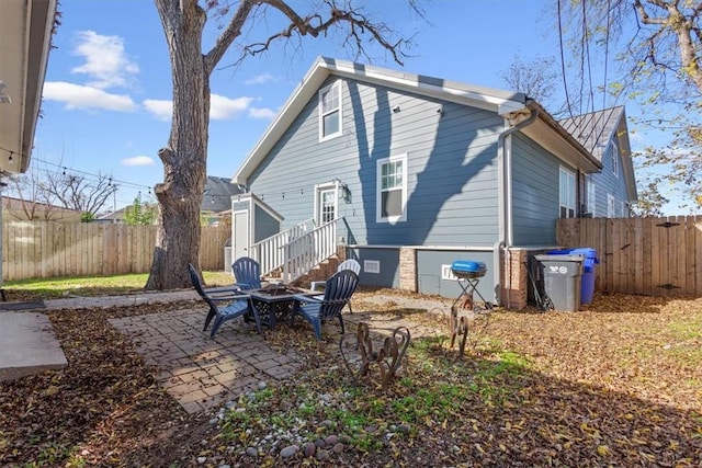 back of property featuring a patio area and an outdoor fire pit