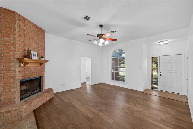 unfurnished living room with ceiling fan, dark hardwood / wood-style flooring, and a fireplace