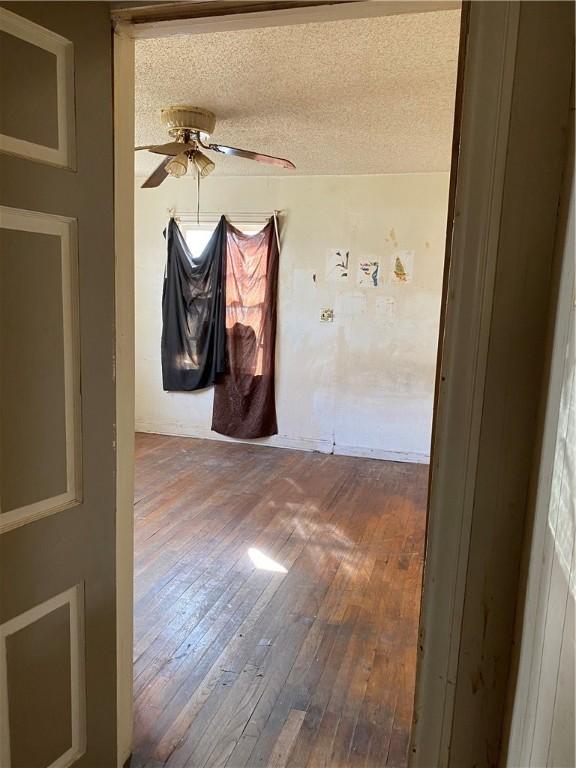 spare room featuring hardwood / wood-style floors, ceiling fan, and a textured ceiling