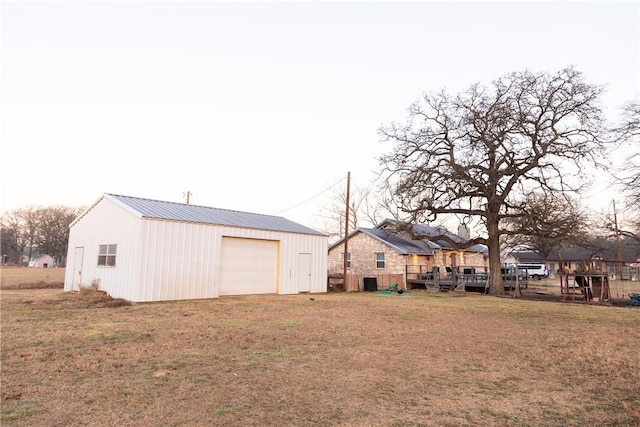 view of yard with a garage and an outbuilding