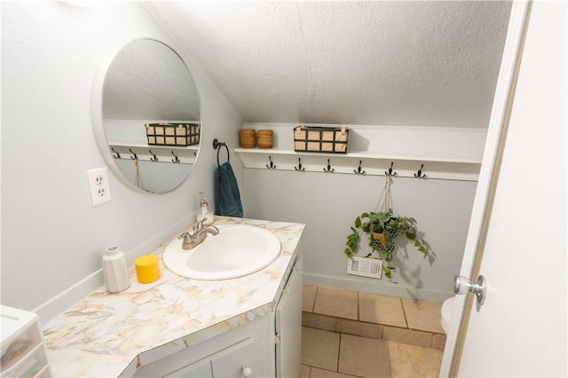 bathroom featuring toilet, tile patterned floors, a textured ceiling, and vanity