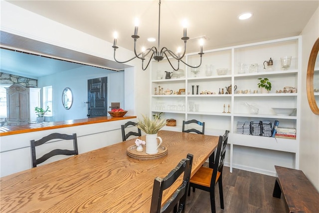 dining space with a chandelier, built in shelves, and dark wood-style flooring