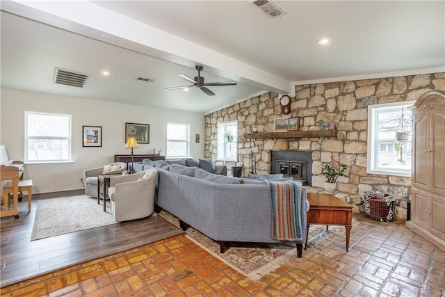 living room featuring vaulted ceiling with beams, brick floor, and visible vents