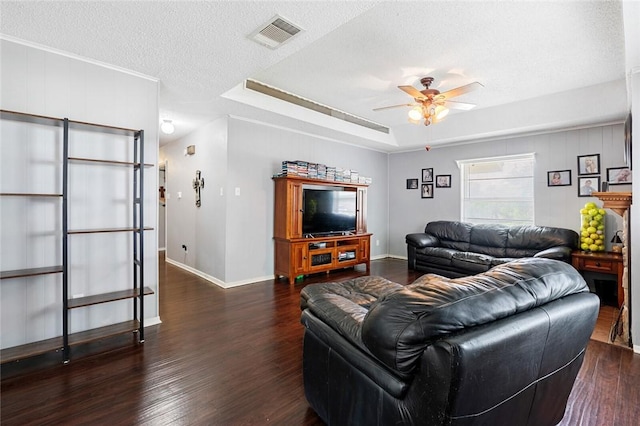 living room featuring a textured ceiling, dark hardwood / wood-style floors, a raised ceiling, and ceiling fan