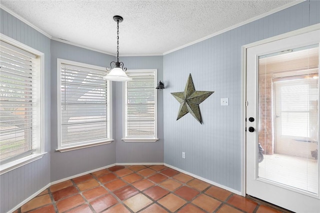 unfurnished dining area featuring tile patterned flooring, crown molding, and a textured ceiling