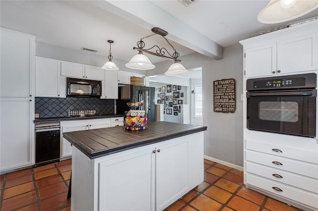 kitchen featuring pendant lighting, a center island, backsplash, black appliances, and white cabinetry