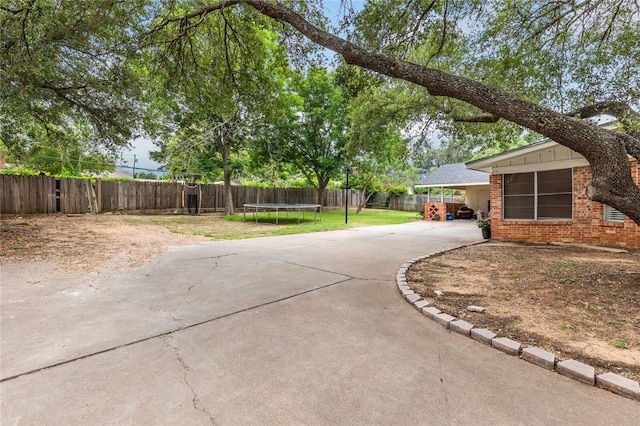 view of yard featuring a carport and a trampoline