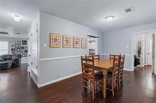 dining room featuring dark hardwood / wood-style floors and a textured ceiling