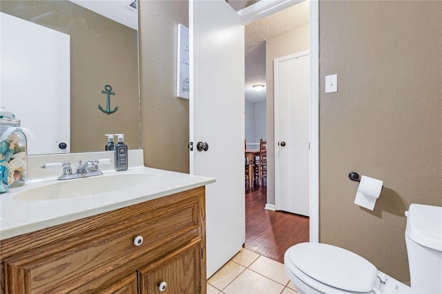 bathroom featuring tile patterned flooring, vanity, and toilet