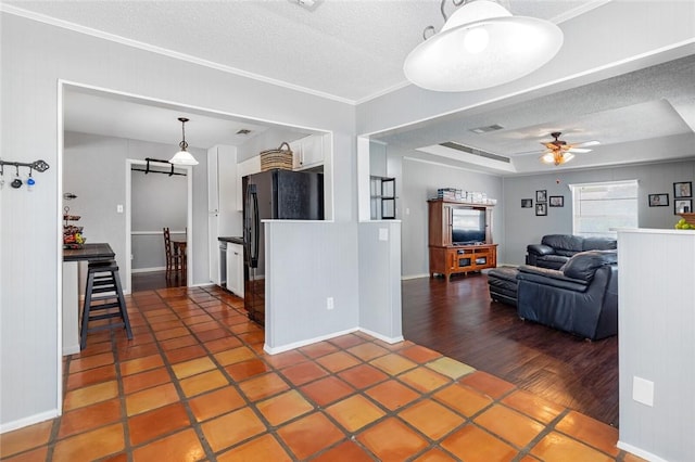 kitchen featuring white cabinets, black refrigerator, crown molding, a textured ceiling, and dark hardwood / wood-style flooring