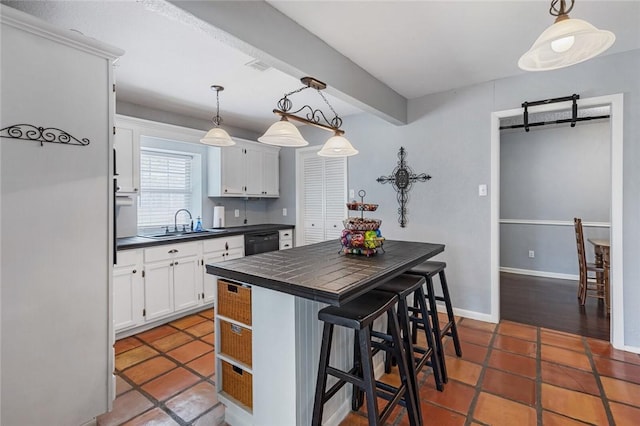 kitchen featuring a breakfast bar area, dishwasher, white cabinets, and hanging light fixtures