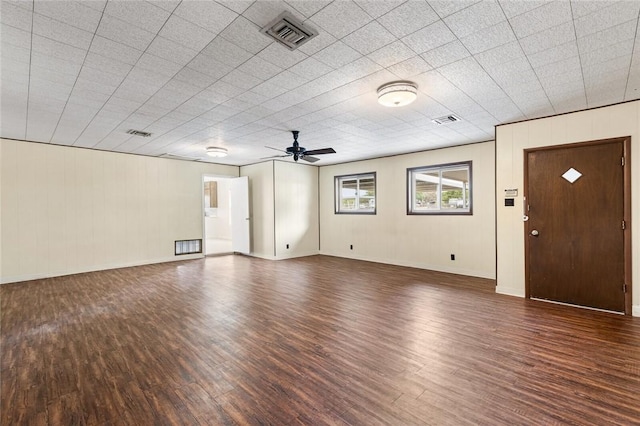 unfurnished living room featuring ceiling fan and dark wood-type flooring