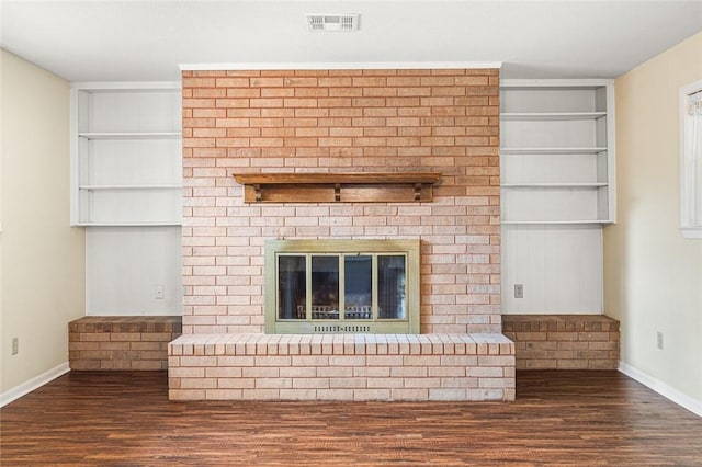 details featuring hardwood / wood-style flooring, built in features, and a brick fireplace