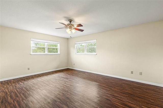 spare room with a textured ceiling, ceiling fan, and dark wood-type flooring