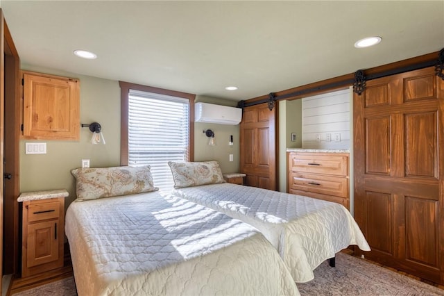 carpeted bedroom with a wall mounted air conditioner and a barn door