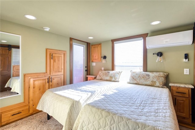 bedroom featuring a barn door and a wall unit AC