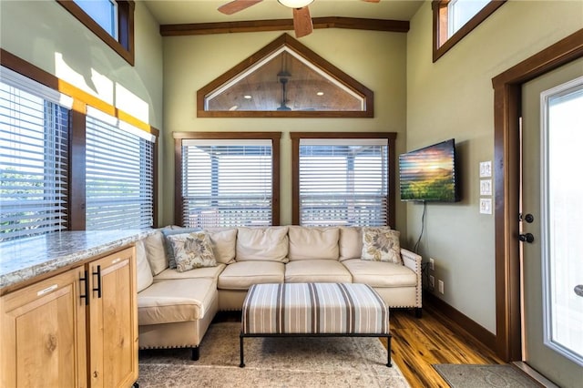 living room featuring a towering ceiling, dark hardwood / wood-style floors, and ceiling fan