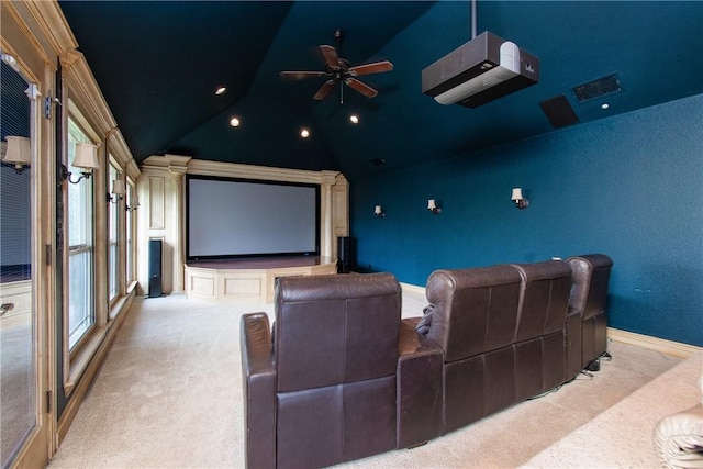 home theater with ceiling fan, light carpet, and vaulted ceiling