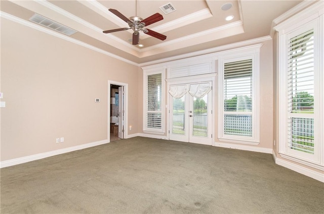 interior space with a raised ceiling, ceiling fan, a healthy amount of sunlight, and ornamental molding