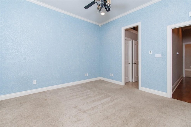 carpeted spare room with ceiling fan and ornamental molding