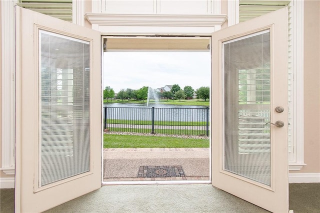 doorway featuring french doors, carpet floors, and a water view