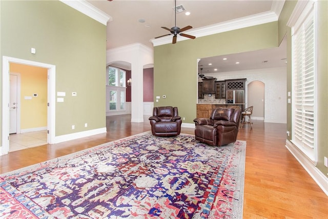 living room with ceiling fan, light hardwood / wood-style floors, and ornamental molding