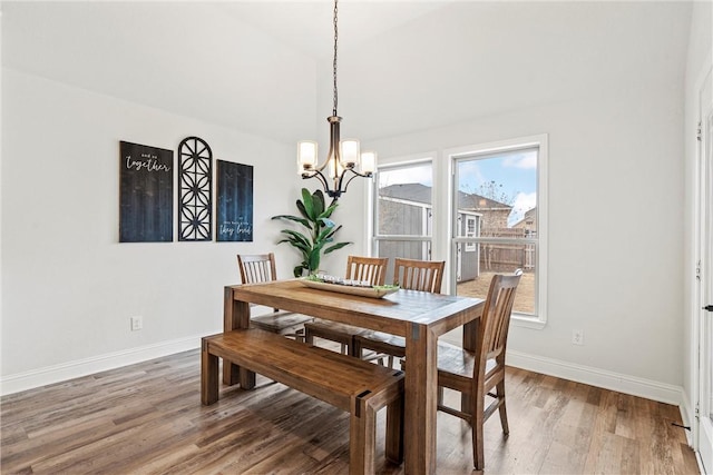 dining area with an inviting chandelier, baseboards, and wood finished floors