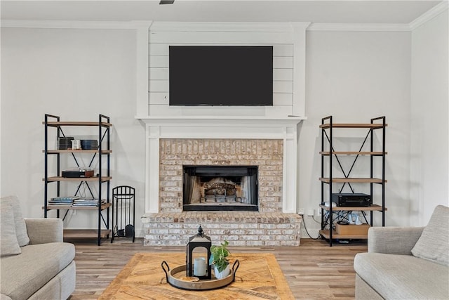 living room featuring a brick fireplace, ornamental molding, and wood finished floors