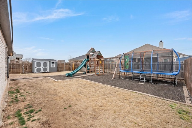 view of jungle gym with an outbuilding, a storage shed, a trampoline, and a fenced backyard