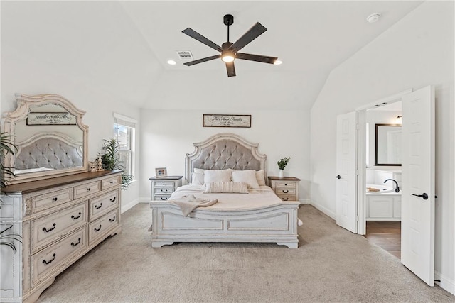 bedroom with light carpet, vaulted ceiling, visible vents, and ensuite bathroom