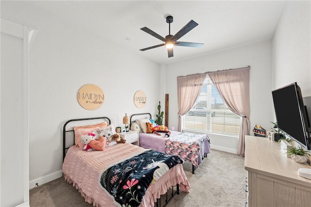 bedroom with light carpet, a ceiling fan, and baseboards