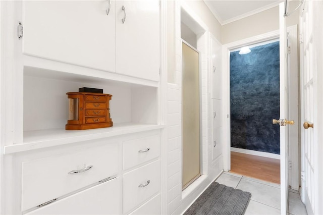 full bathroom with ornamental molding, a shower stall, and tile patterned floors