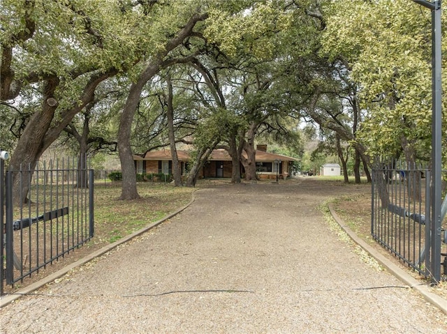 single story home featuring driveway, a gate, and fence