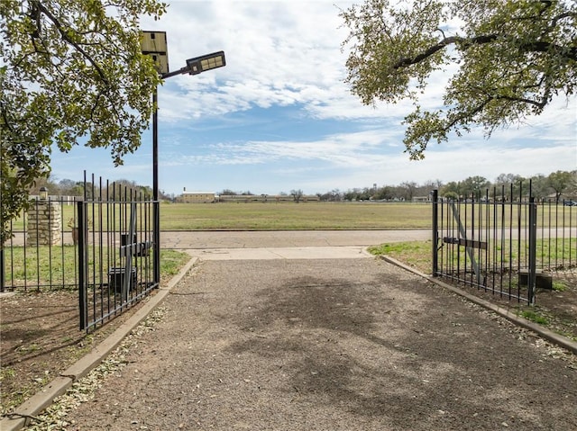 exterior space featuring a rural view, fence, and a lawn