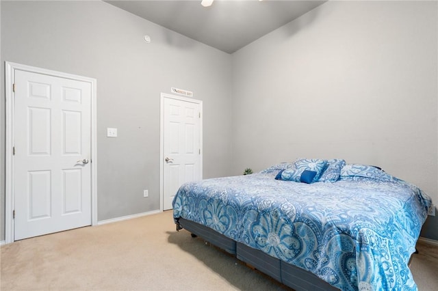 bedroom featuring baseboards and light colored carpet